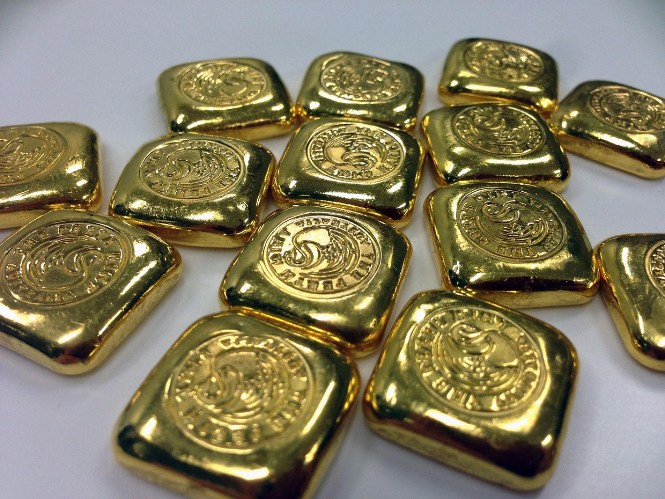 Close-up of polished gold bars stacked, symbolizing secure investment when you buy gold bars from bank-approved dealers like