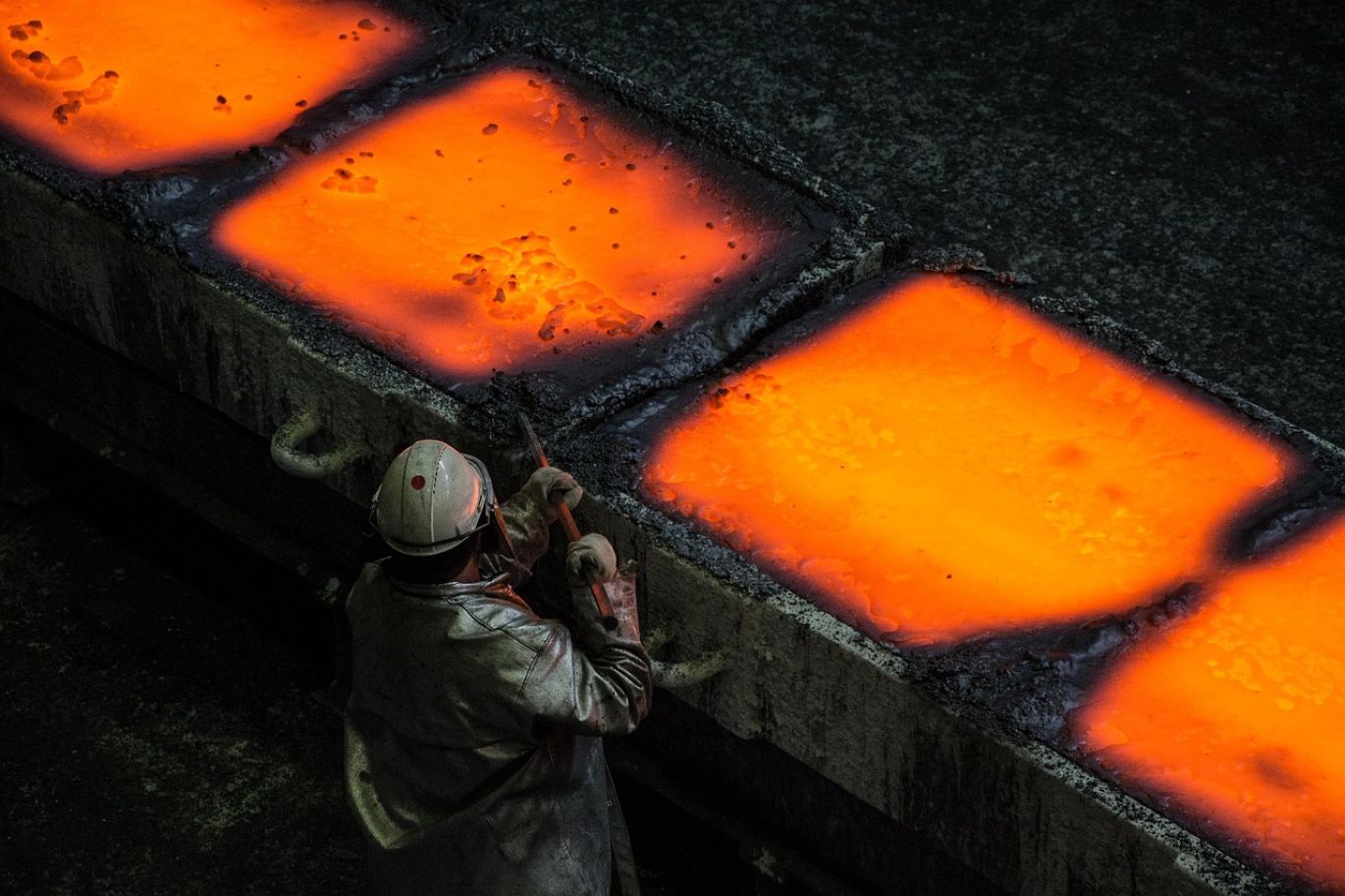 Workers overseeing the Ferro Silicon Magnesium Manufacturing Process in an industrial furnace at a production facility.
