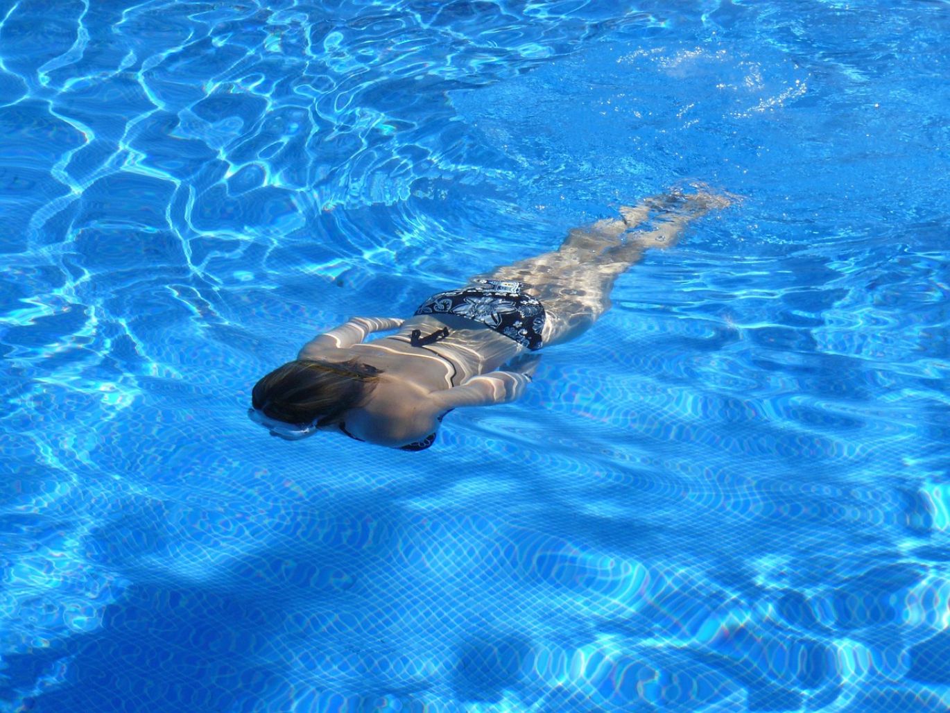 White powder of soda bicarbonate being added to a swimming pool for chemical balance.